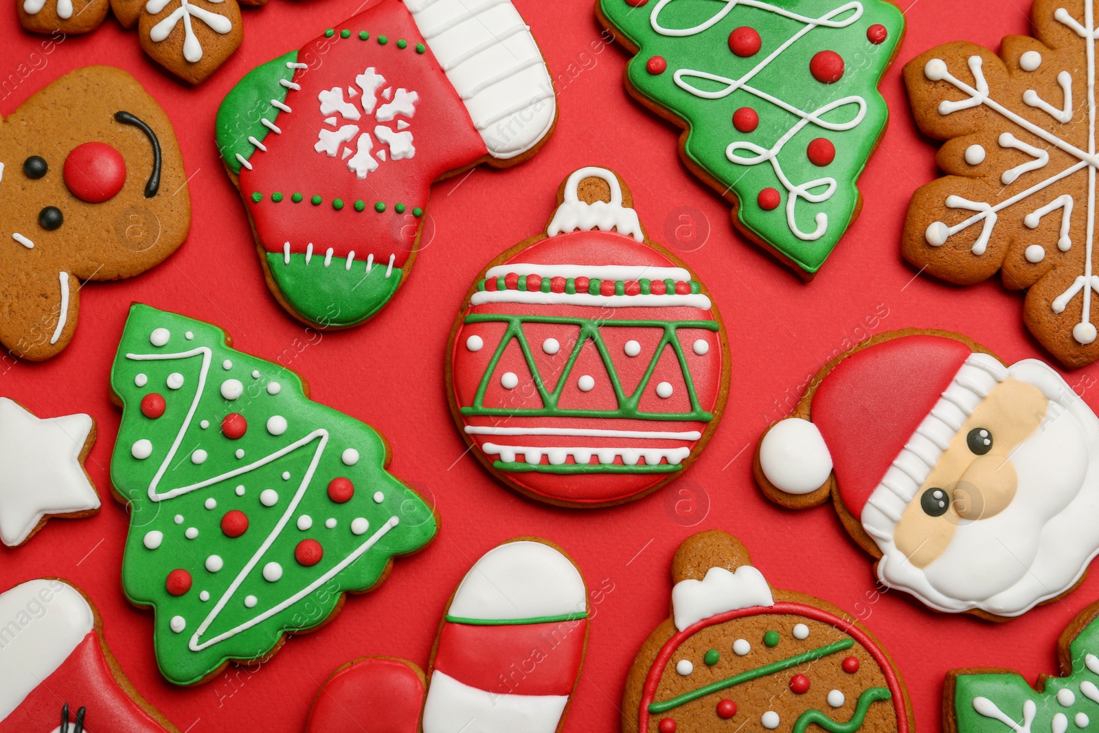 Photo of Different tasty Christmas cookies on red background, flat lay