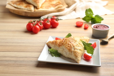 Photo of Fresh delicious puff pastry served on wooden table