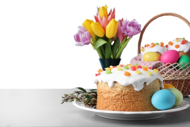 Photo of Beautiful Easter cake and painted eggs on light grey table against white background. Space for text