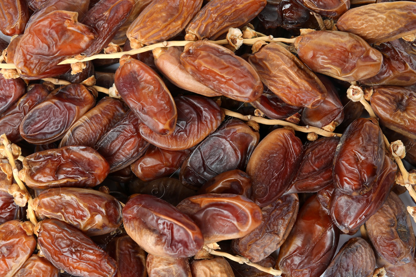 Photo of Sweet dried dates on branches as background, top view. Healthy snack