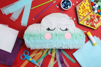 Photo of Flat lay composition with cardboard cloud on red background. Pinata diy
