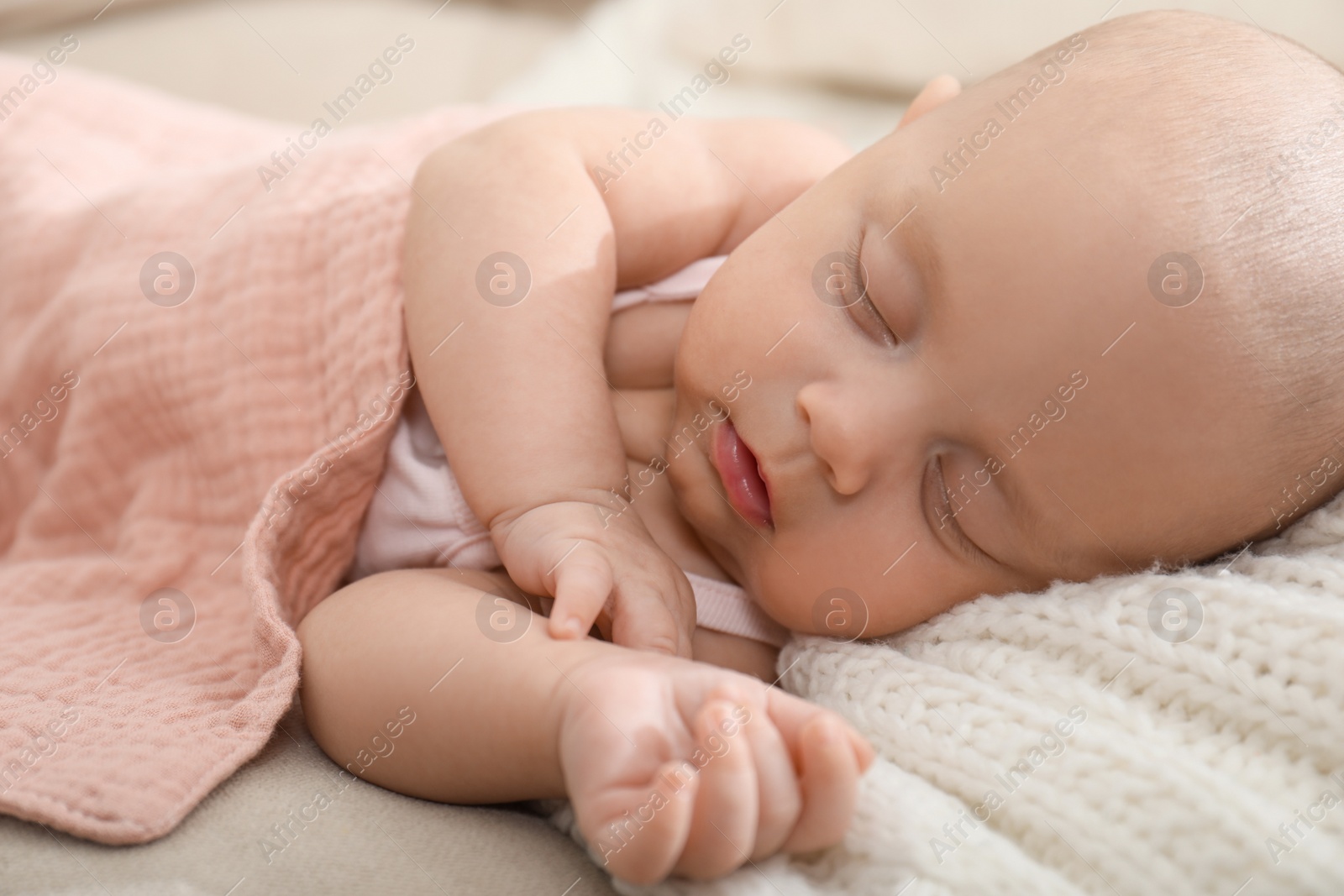 Photo of Cute little baby sleeping on blanket at home, closeup