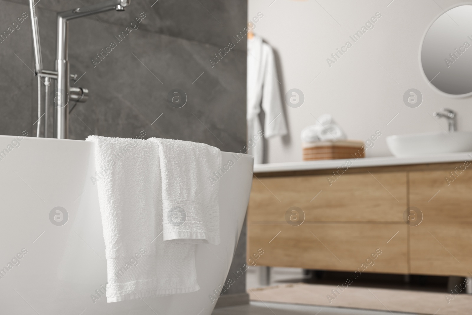 Photo of Fresh white towels on tub in bathroom. Space for text