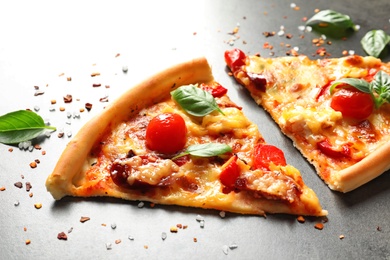 Photo of Slices of tasty pizza with tomatoes and sausages on table