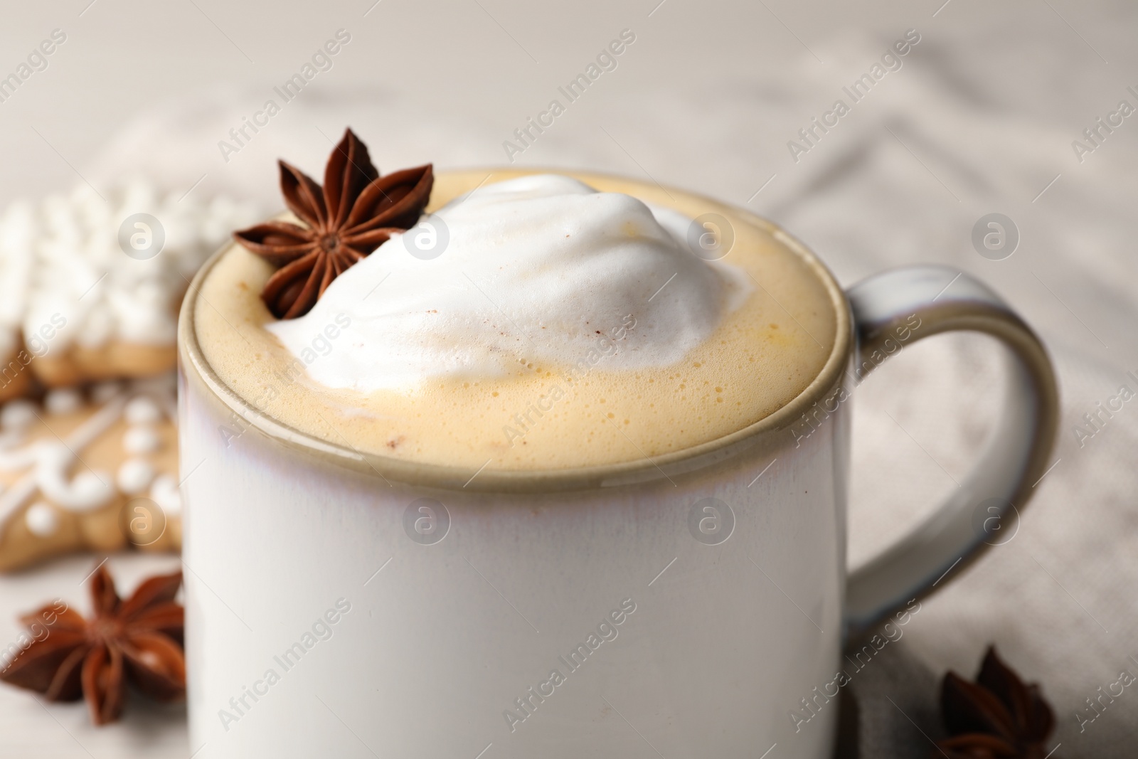 Photo of Cup of delicious eggnog with anise star on table, closeup