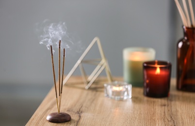 Incense sticks smoldering on table indoors, space for text