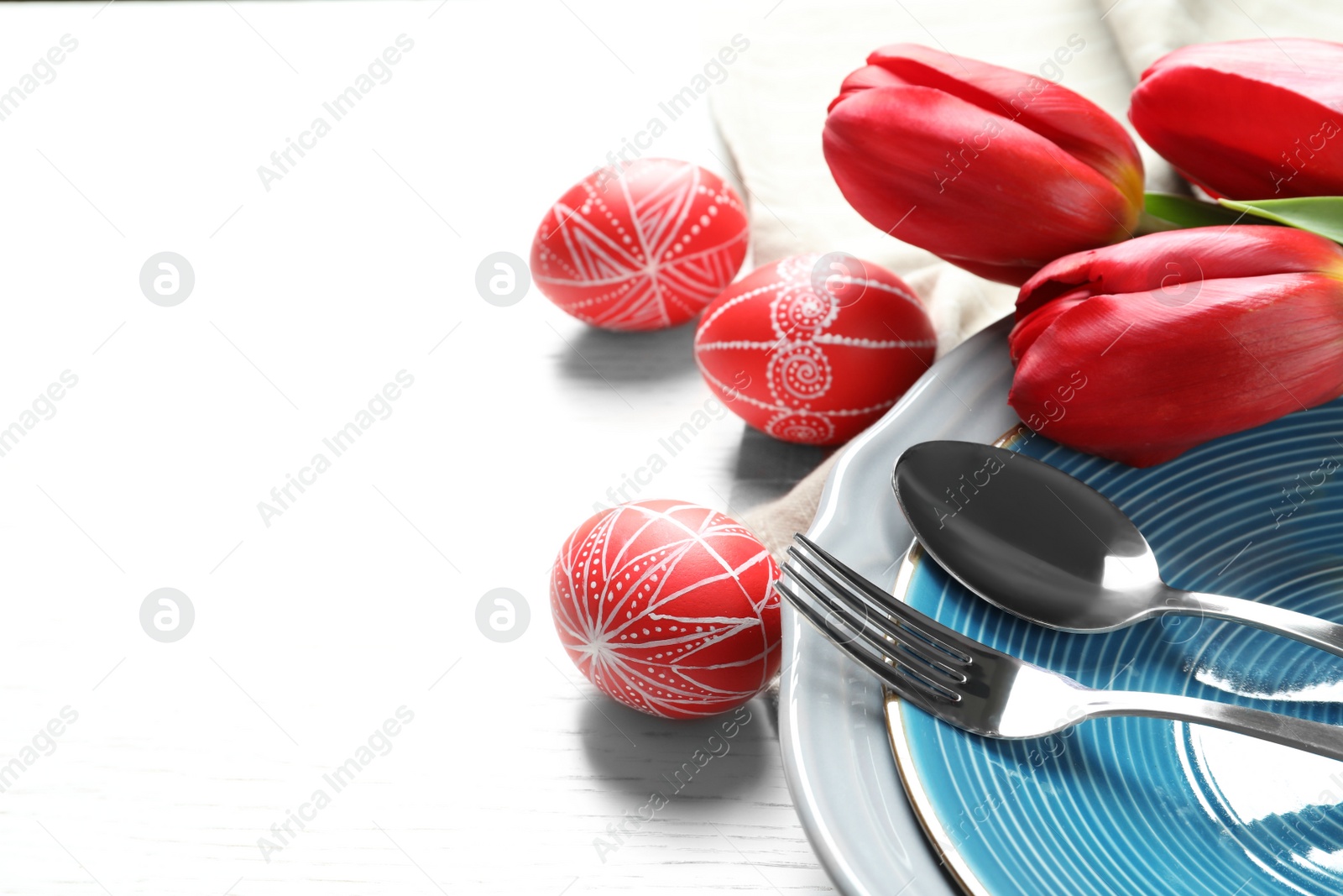 Photo of Festive Easter table setting with painted eggs on wooden background, space for text