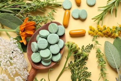 Photo of Different pills, herbs and flowers on pale orange background, flat lay. Dietary supplements