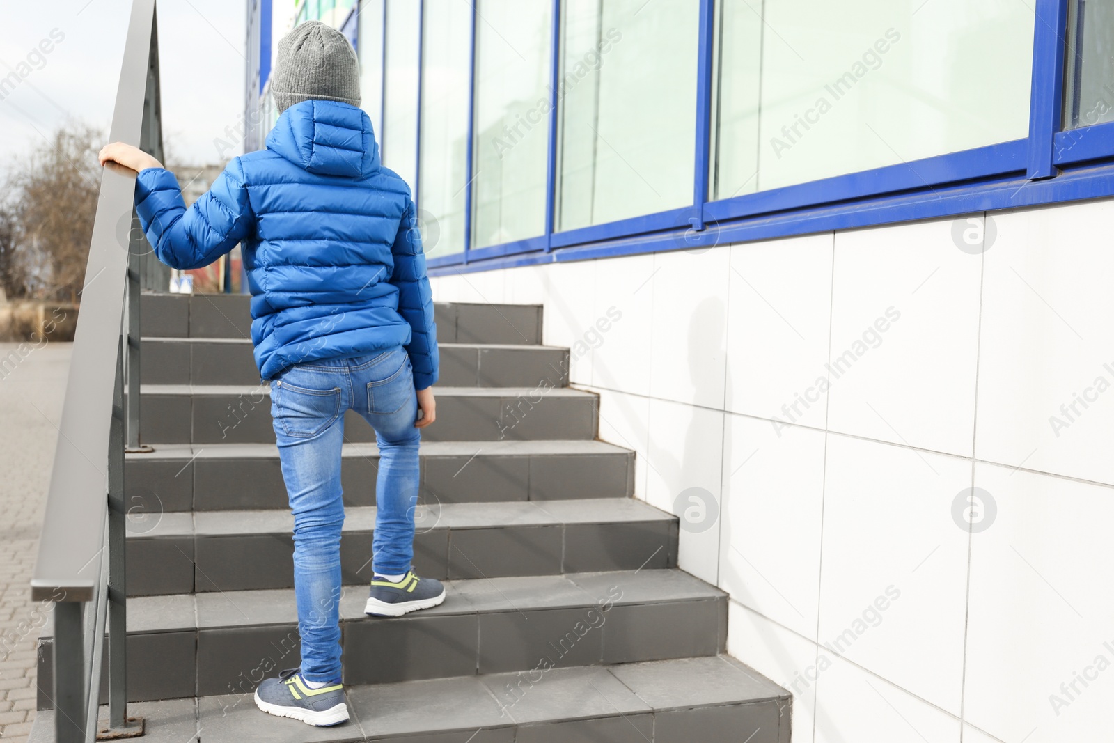 Photo of Lonely little boy on stairs outdoors. Autism concept