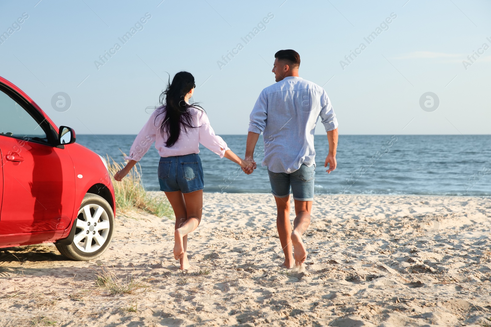 Photo of Lovely couple running on sandy beach. Summer trip