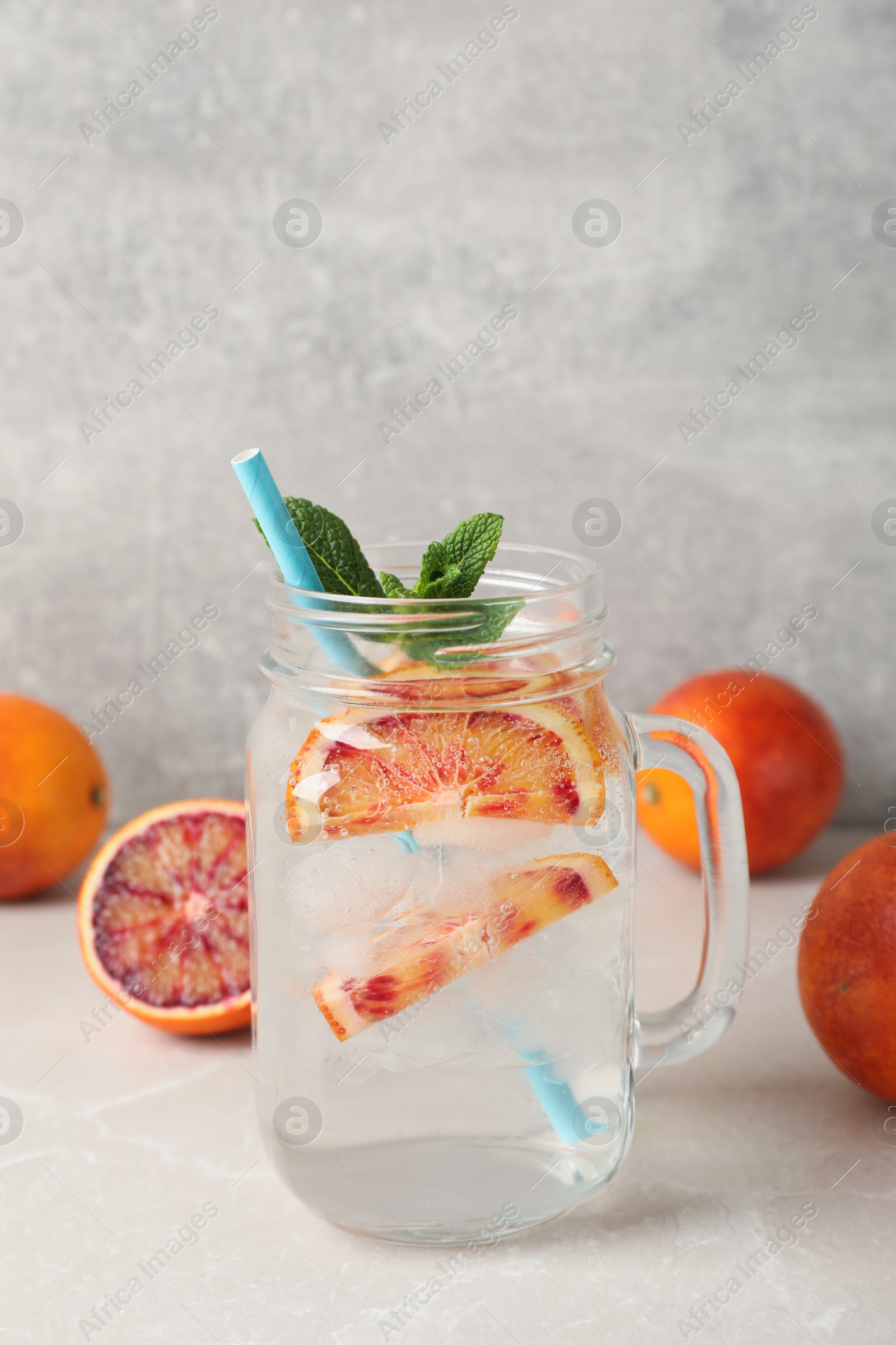 Photo of Delicious refreshing drink with sicilian orange and mint on grey table