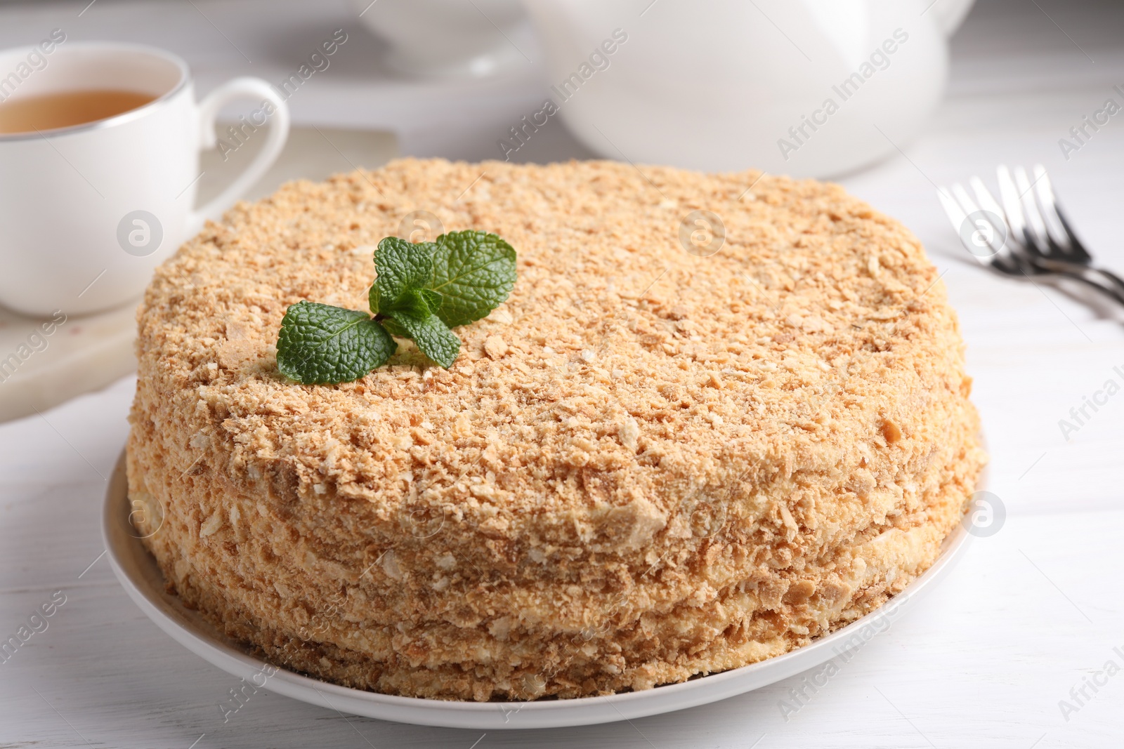 Photo of Delicious Napoleon cake served on white wooden table, closeup