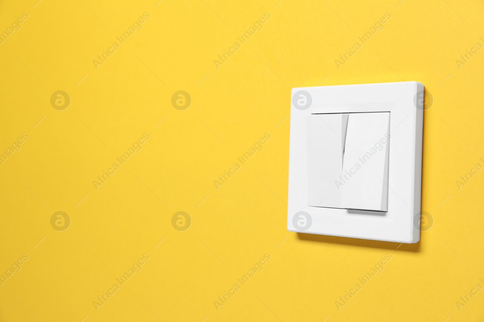 Photo of Modern plastic light switch on orange background. Space for text