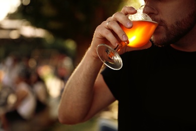 Photo of Man drinking cold tasty beer at festival