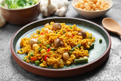 Photo of Delicious rice pilaf with vegetables on grey table