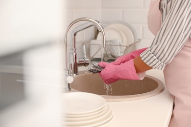 Photo of Woman doing washing up in kitchen sink, closeup view. Cleaning chores