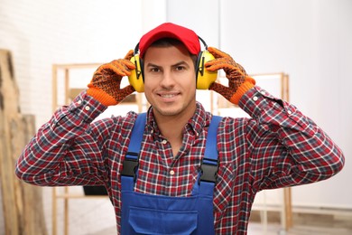 Photo of Worker wearing safety headphones indoors. Hearing protection device