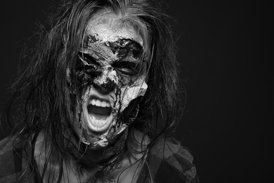 Scary zombie on dark background, black and white effect. Halloween monster