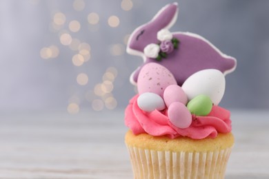 Tasty cupcake with Easter decor on table, closeup. Space for text