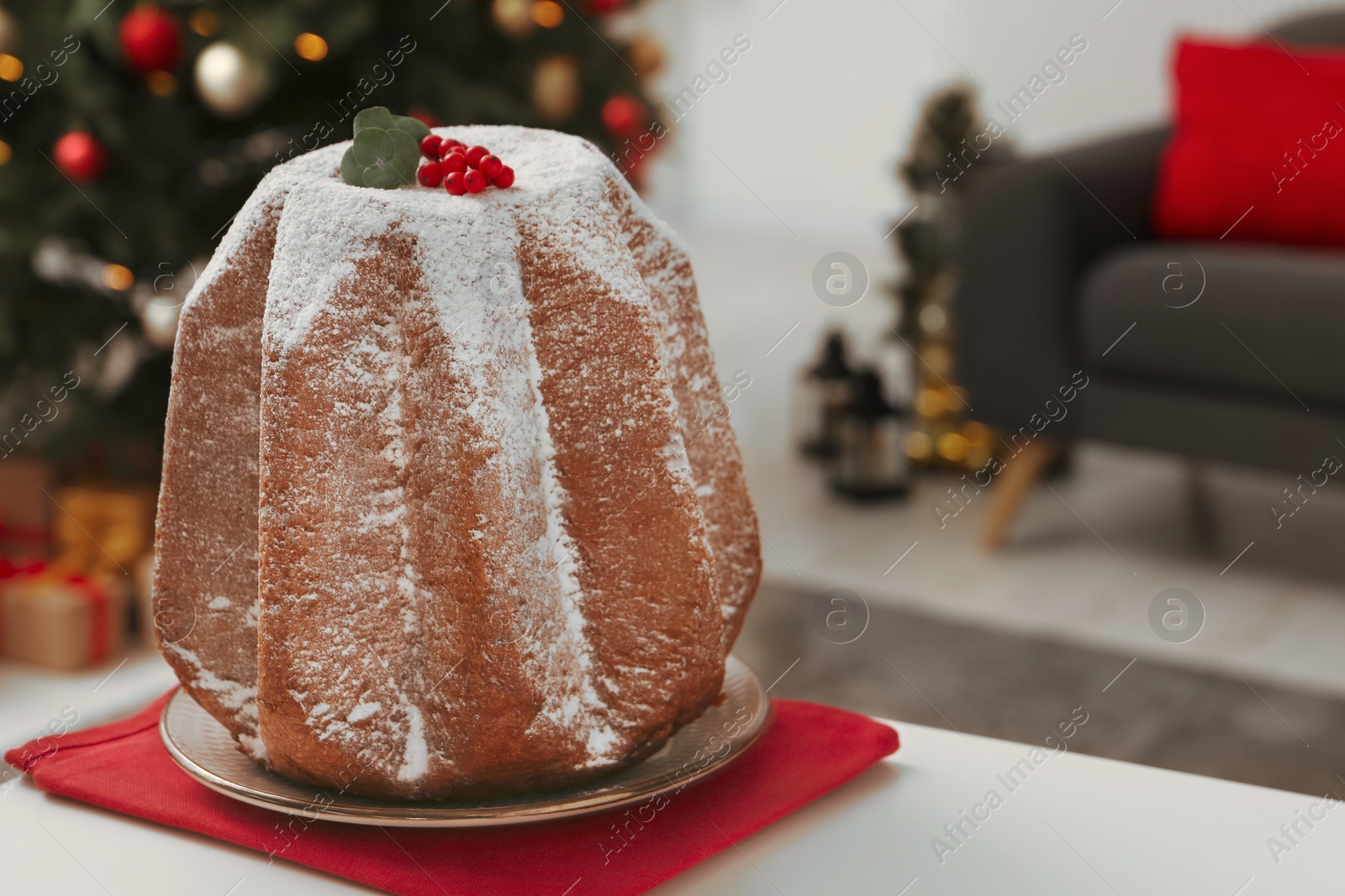 Photo of Traditional Italian pastry. Delicious Pandoro cake decorated with powdered sugar on white table in room, closeup and space for text