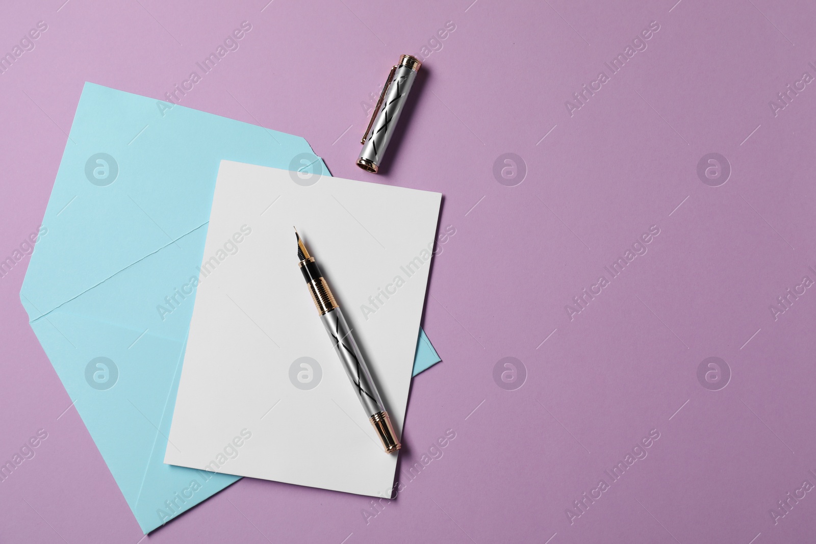 Photo of Blank sheet of paper, letter envelope and pen on violet background, top view. Space for text