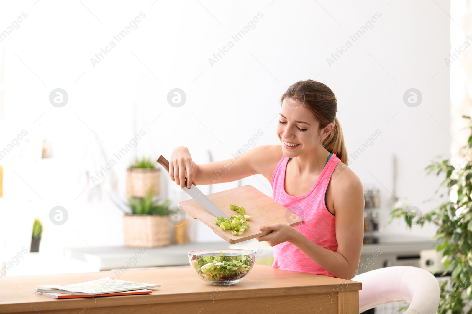 Photo of Young woman in fitness clothes preparing healthy breakfast at home