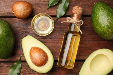 Photo of Cooking oil and fresh avocados on wooden table, flat lay