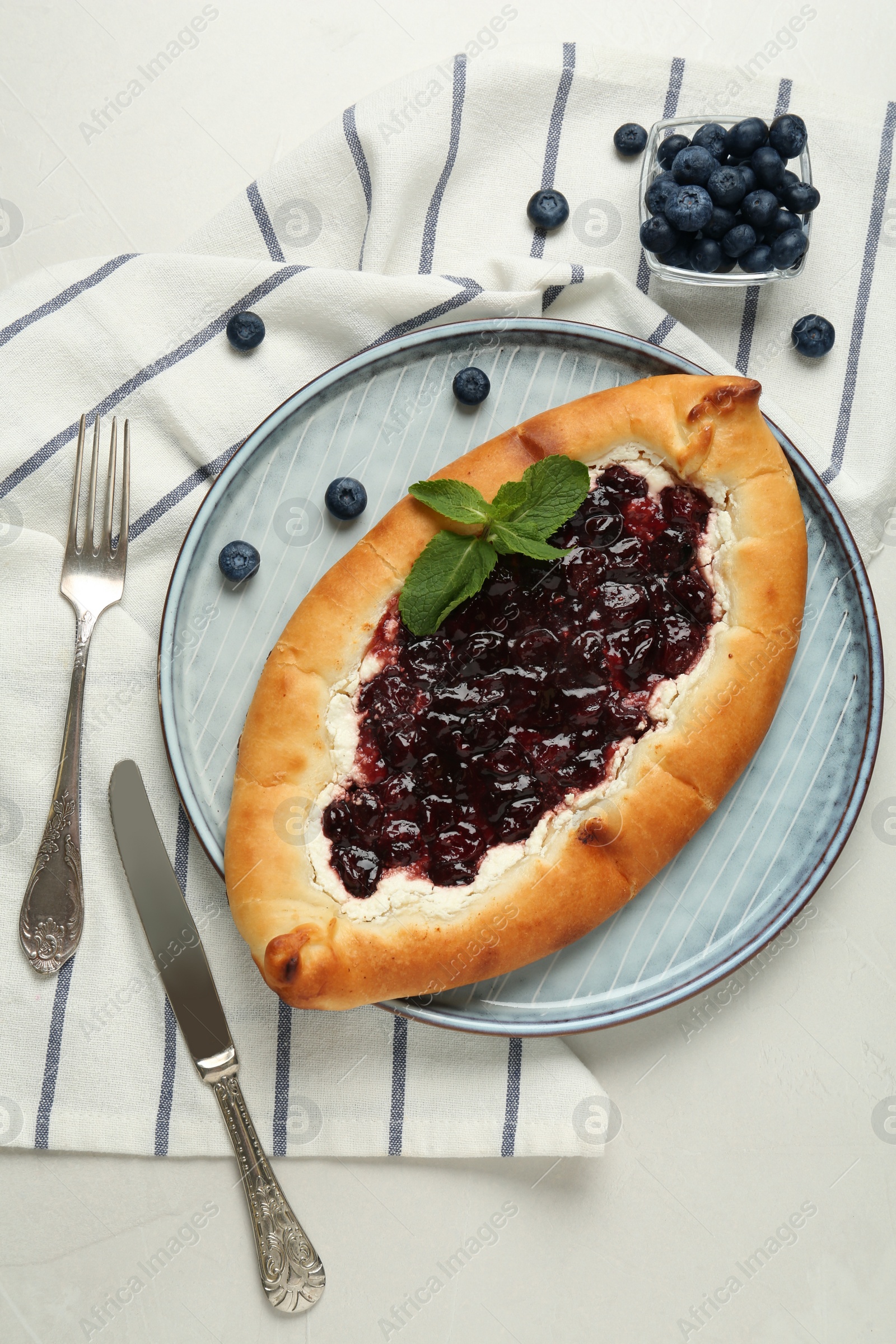 Photo of Delicious sweet cottage cheese pastry with cherry jam served on light table, flat lay