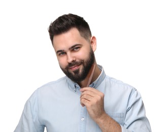 Handsome young man combing beard on white background