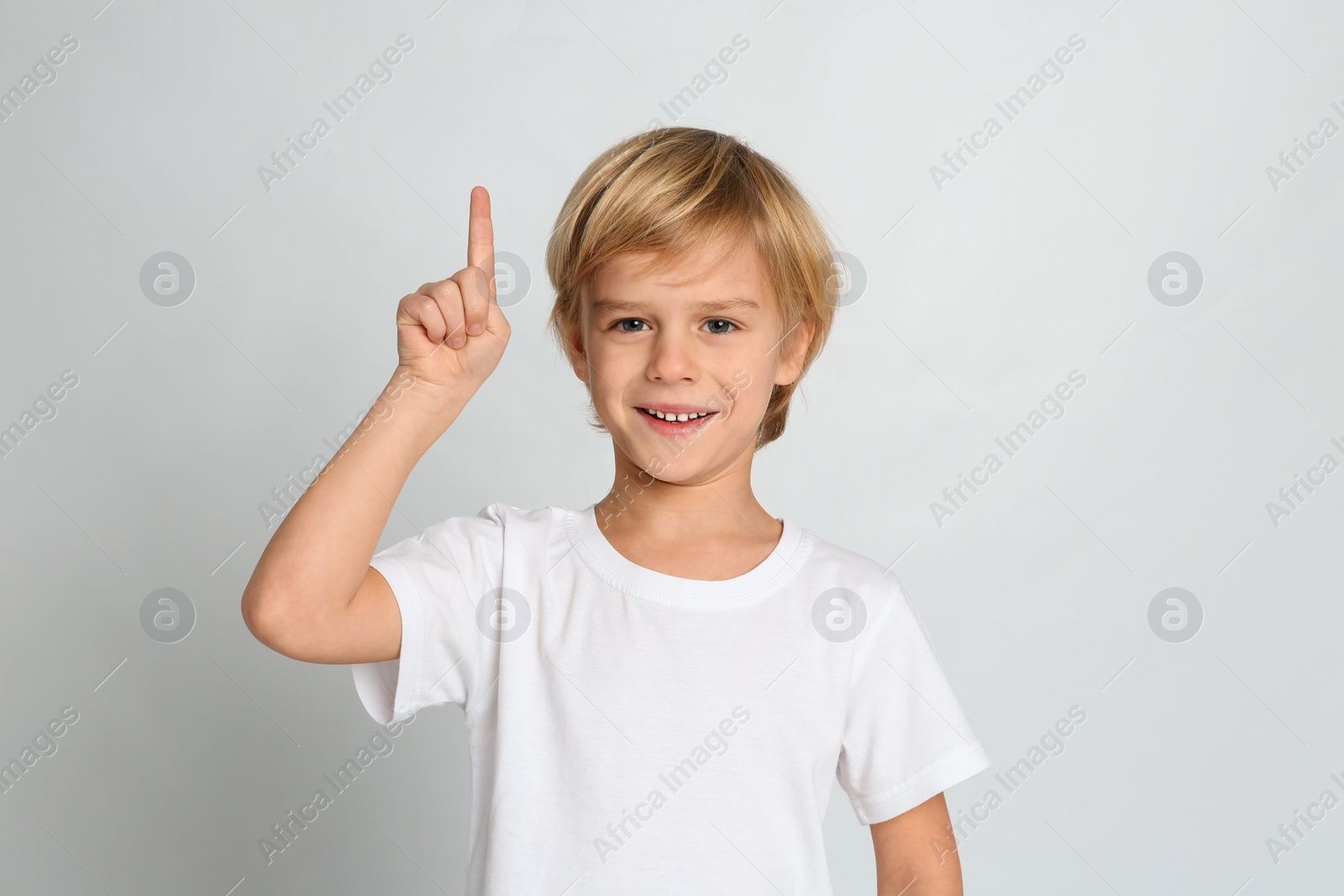 Photo of Portrait of cute little boy on light grey background