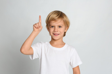 Photo of Portrait of cute little boy on light grey background
