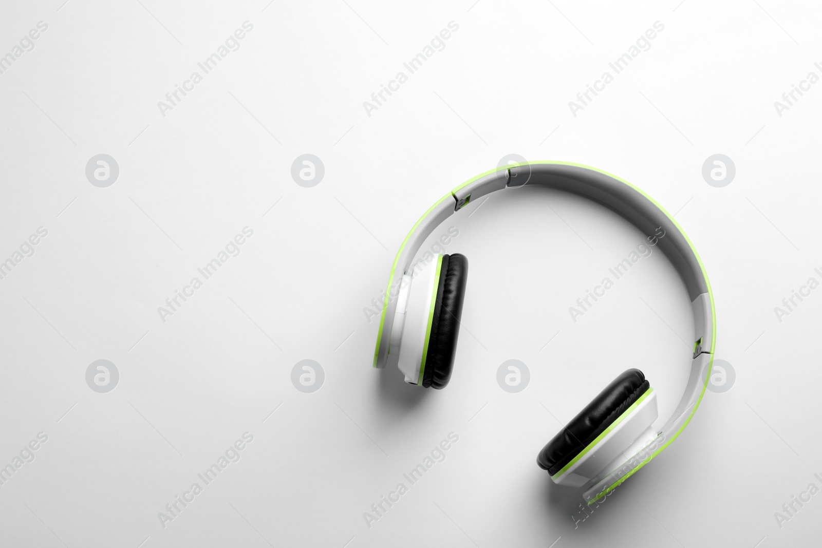 Photo of Stylish modern headphones with earmuffs on white background, top view. Space for text