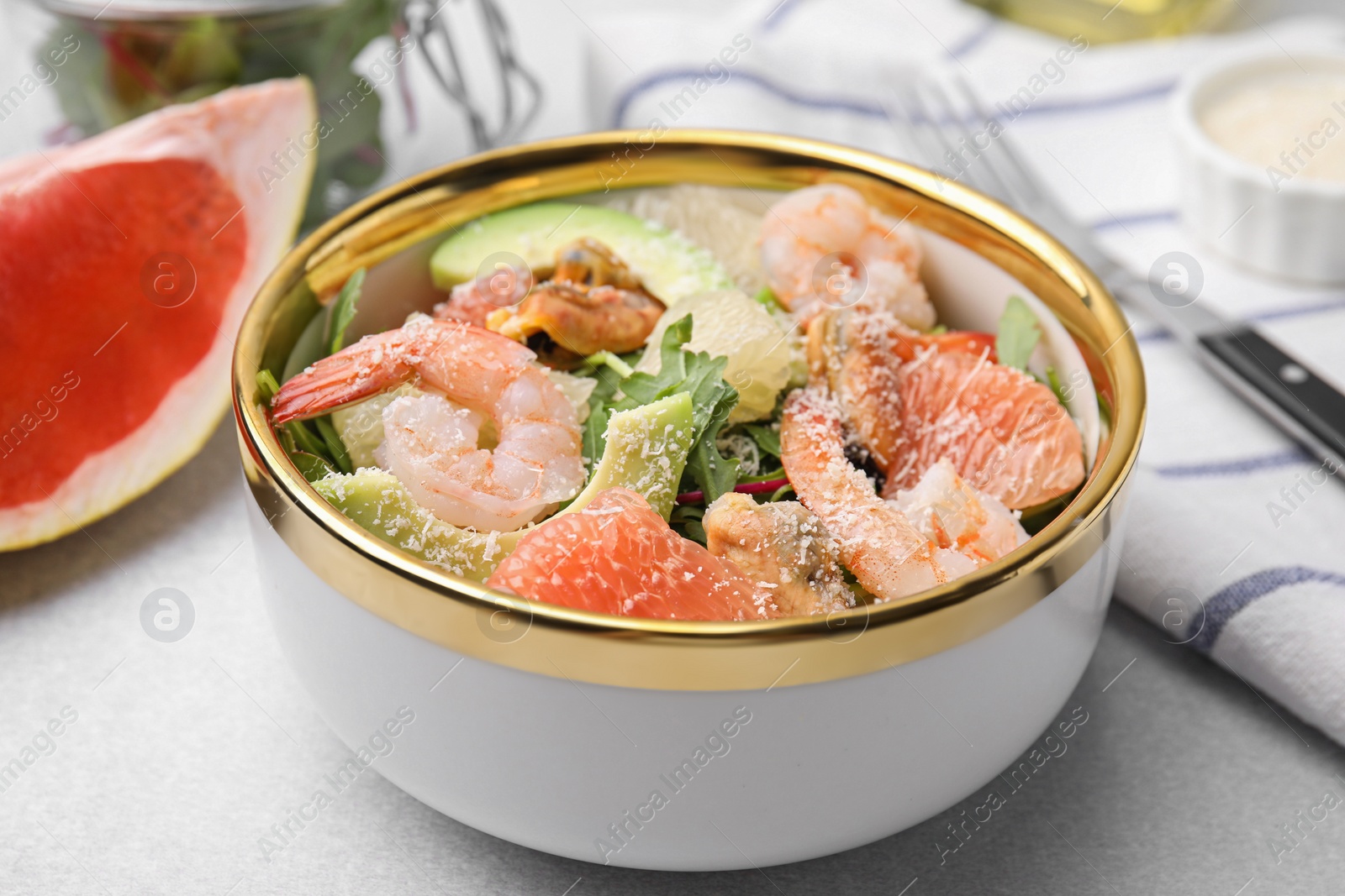 Photo of Delicious pomelo salad with shrimps served on light grey table, closeup