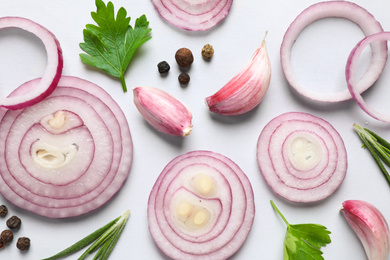 Photo of Flat lay composition with sliced onion and spices on light background