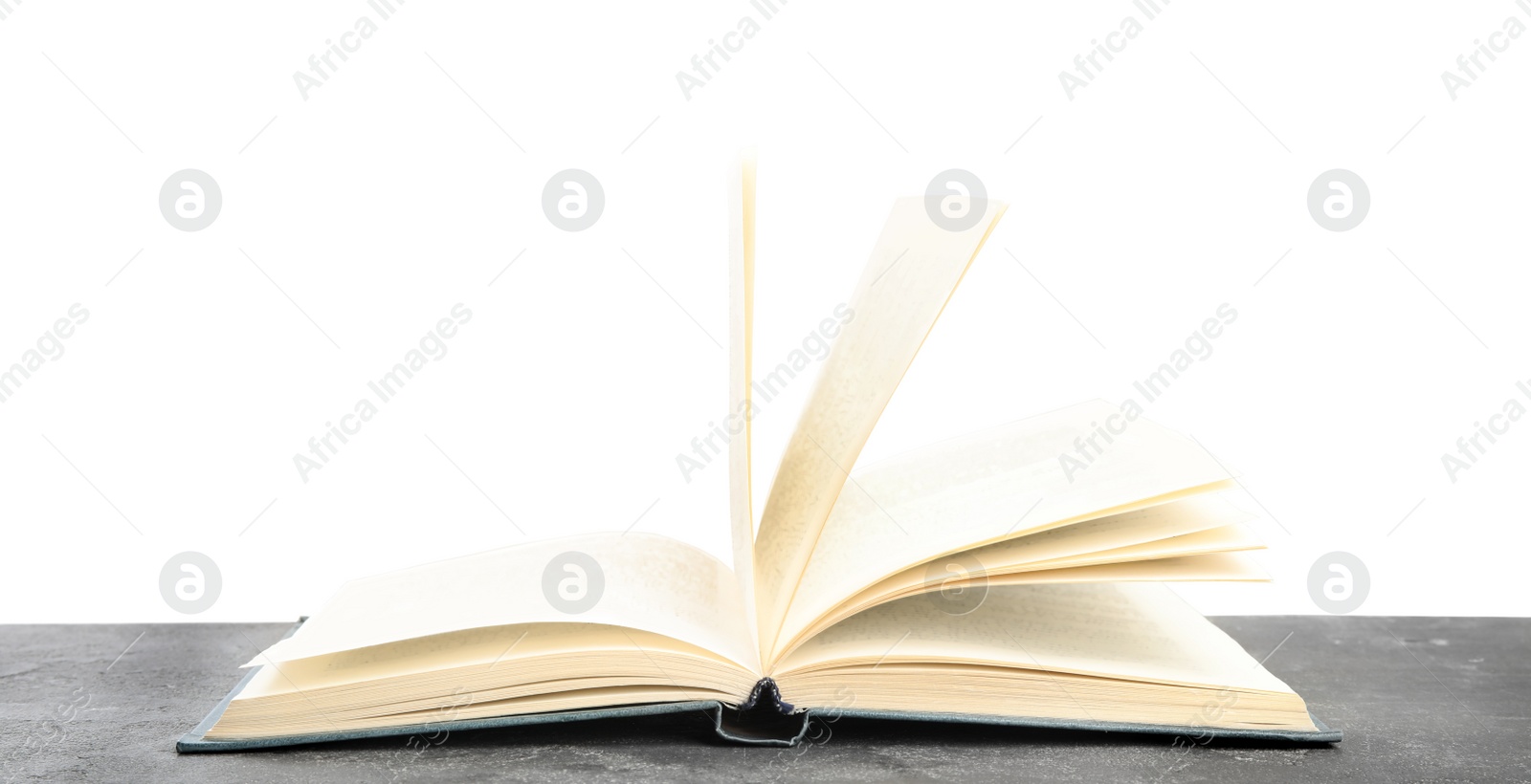 Photo of Open book on grey stone table against white background