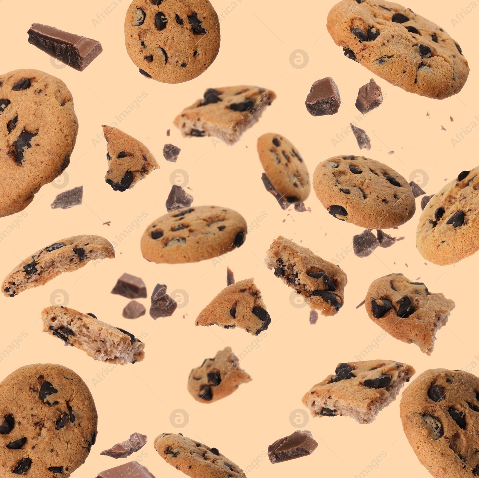 Image of Delicious chocolate chip cookies and pieces of chocolate falling on beige background