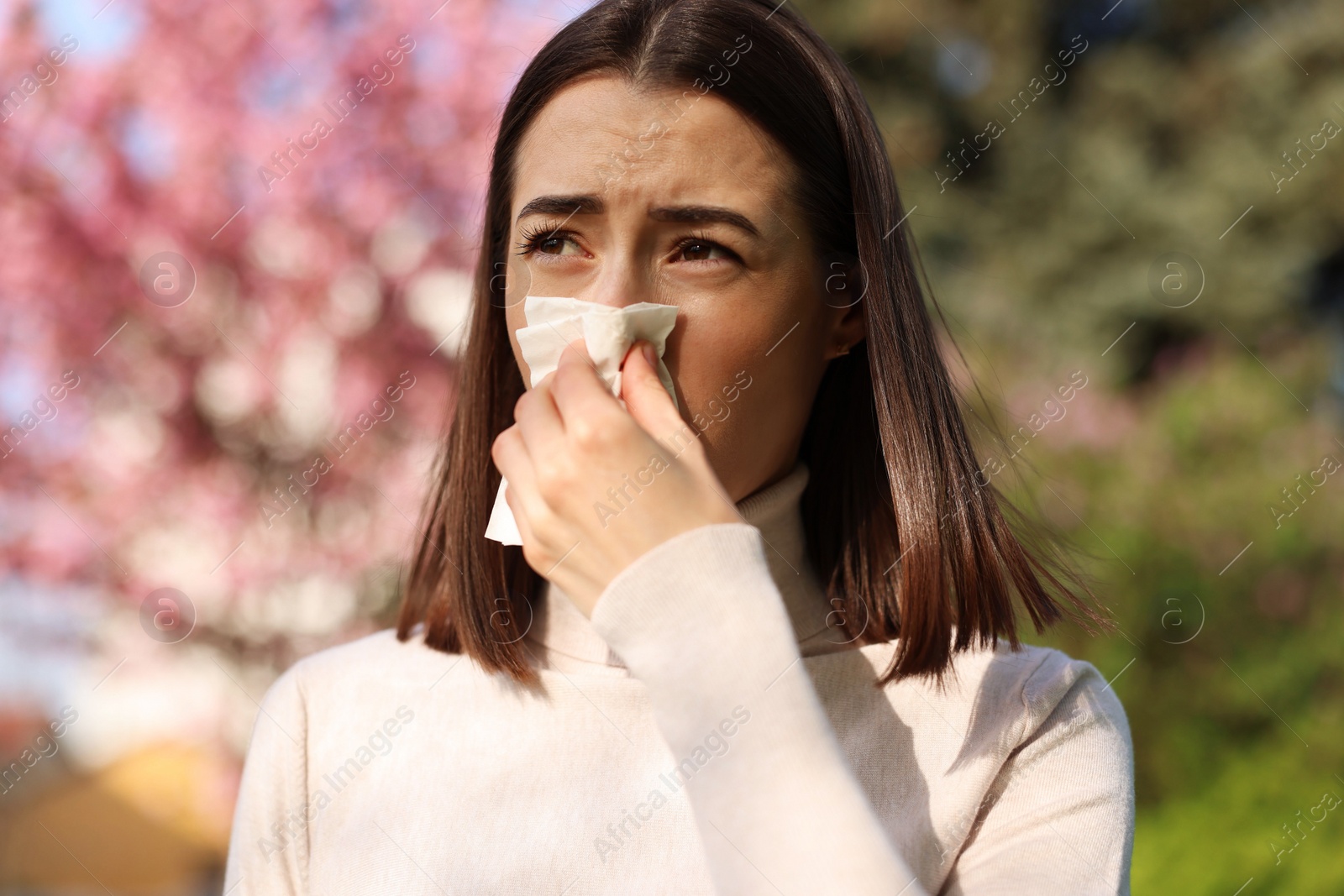 Photo of Woman with napkin suffering from seasonal allergy on spring day