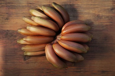 Tasty purple bananas on wooden table, top view