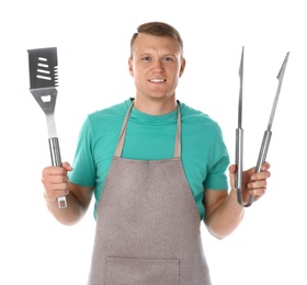 Photo of Man in apron with barbecue utensils on white background