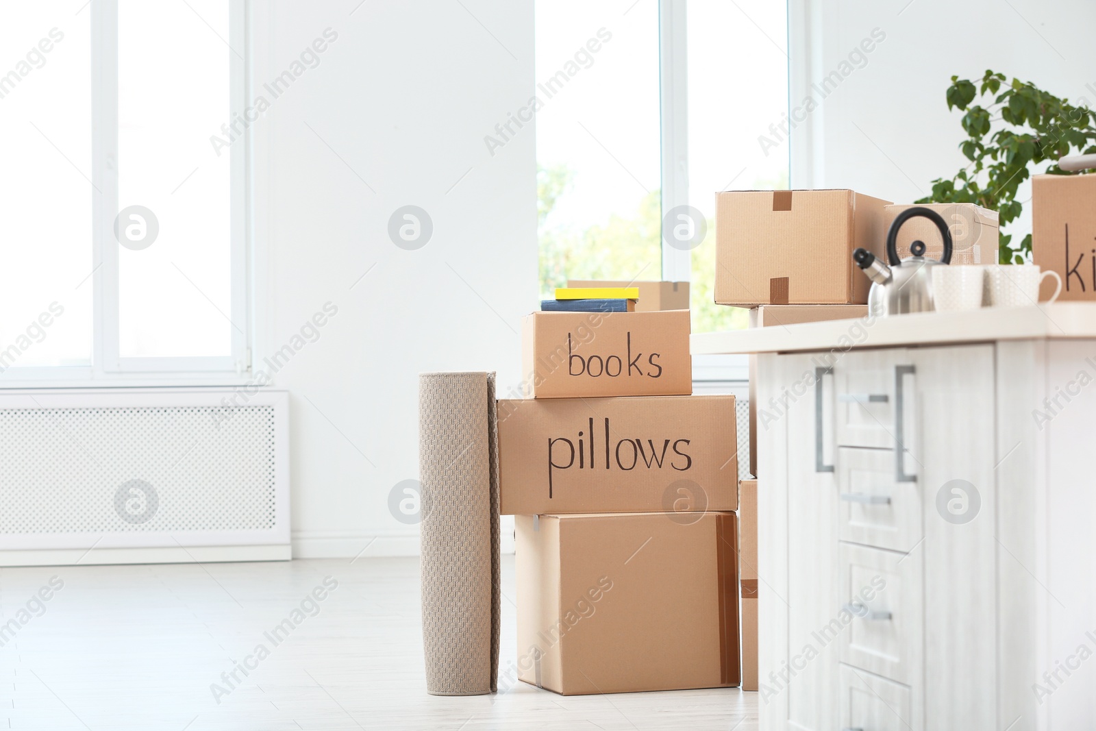 Photo of Moving boxes and household stuff in room. Space for text