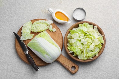 Photo of Cut fresh Chinese cabbage, oil and salt on light table, flat lay