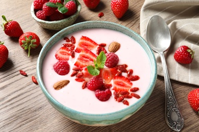 Smoothie bowl with goji berries and spoon on wooden table