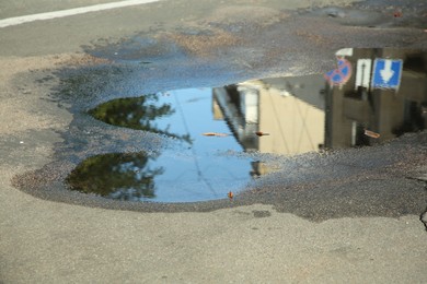Photo of Puddle of rain water on asphalt outdoors
