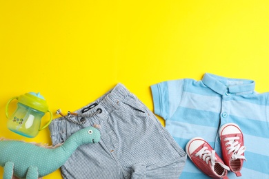 Photo of Flat lay composition with clothes and space for text on color background. Baby accessories