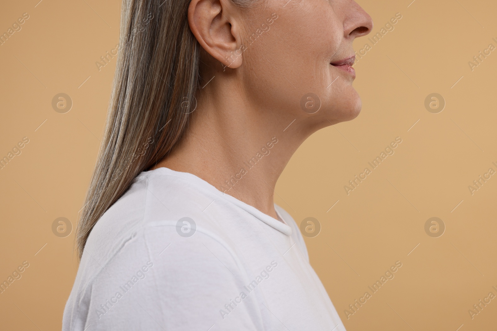 Photo of Mature woman with healthy skin on beige background, closeup