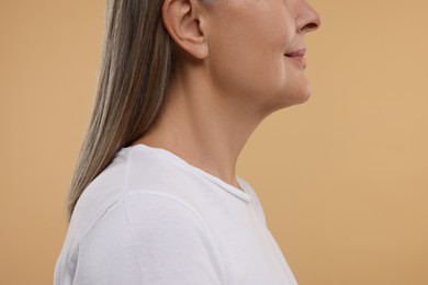 Photo of Mature woman with healthy skin on beige background, closeup