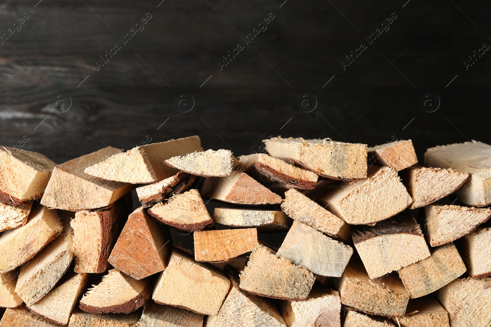 Photo of Cut firewood on black background. Heating in winter