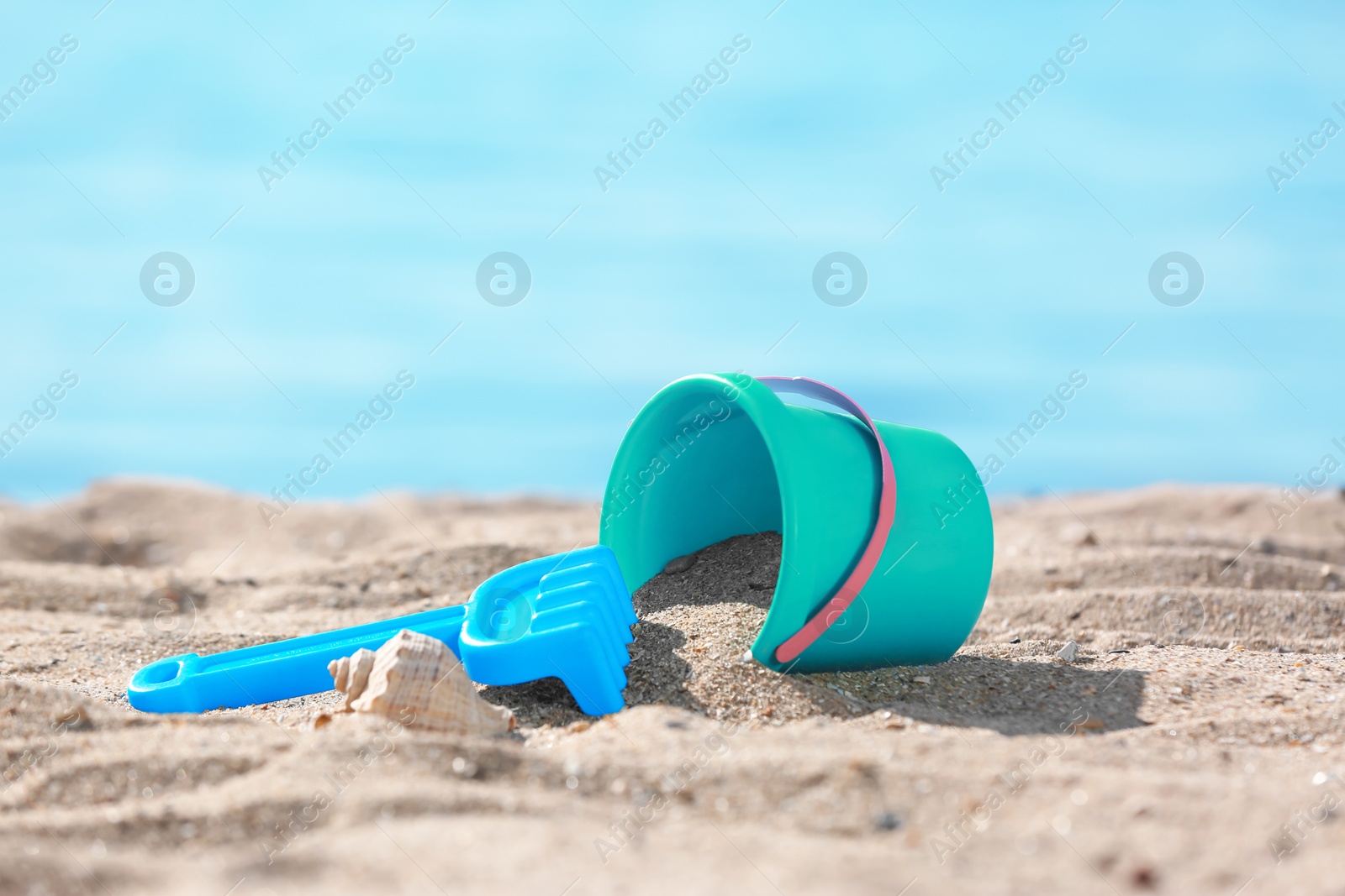 Photo of Children toys on sand near sea. Beach object