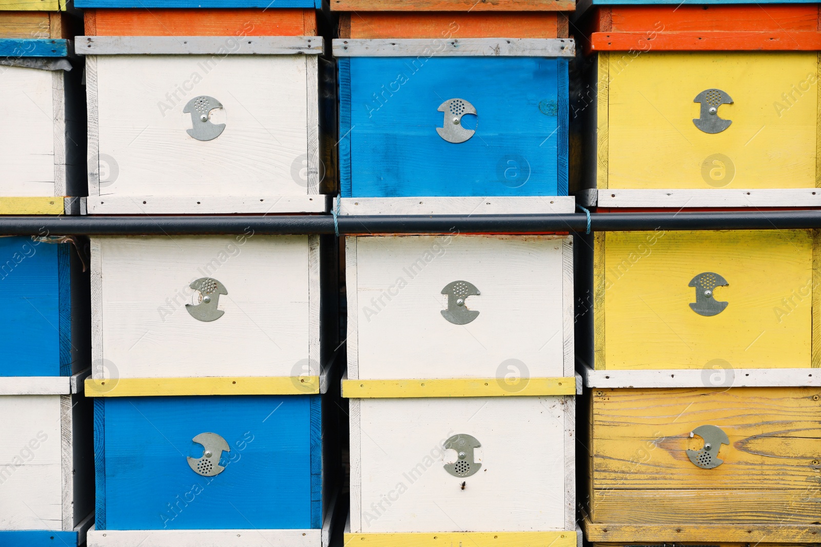 Photo of Many colorful bee hives at apiary, closeup