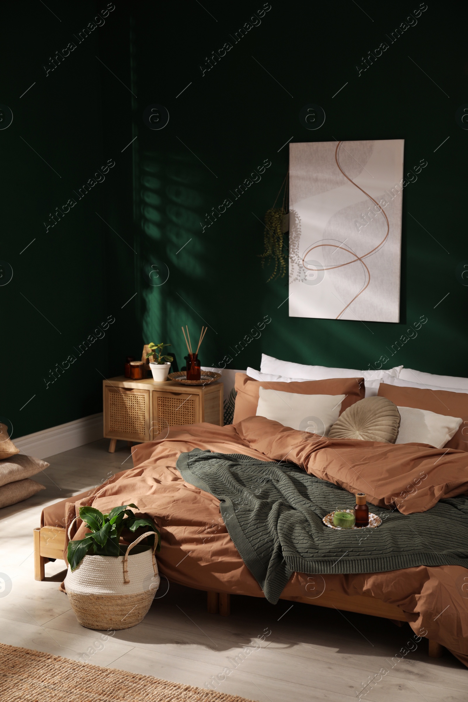 Photo of Stylish interior with large comfortable bed and potted plants